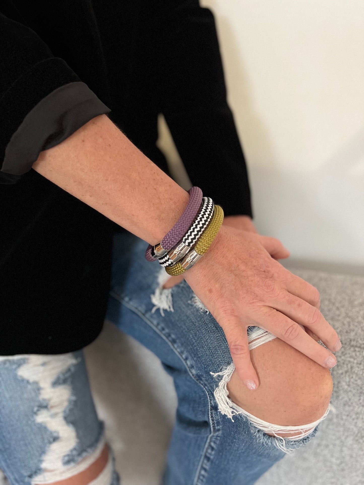 Person wearing multiple bracelets on a blurred background